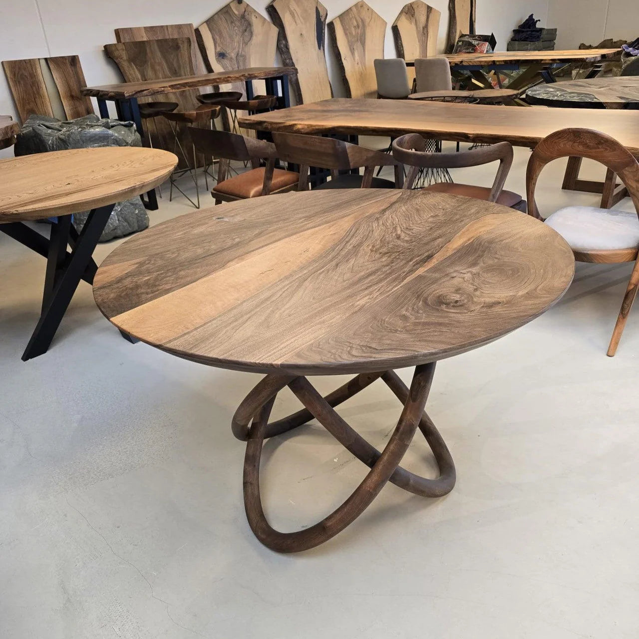 Rundt plankebord i valnød med speciel bordben i valnød.