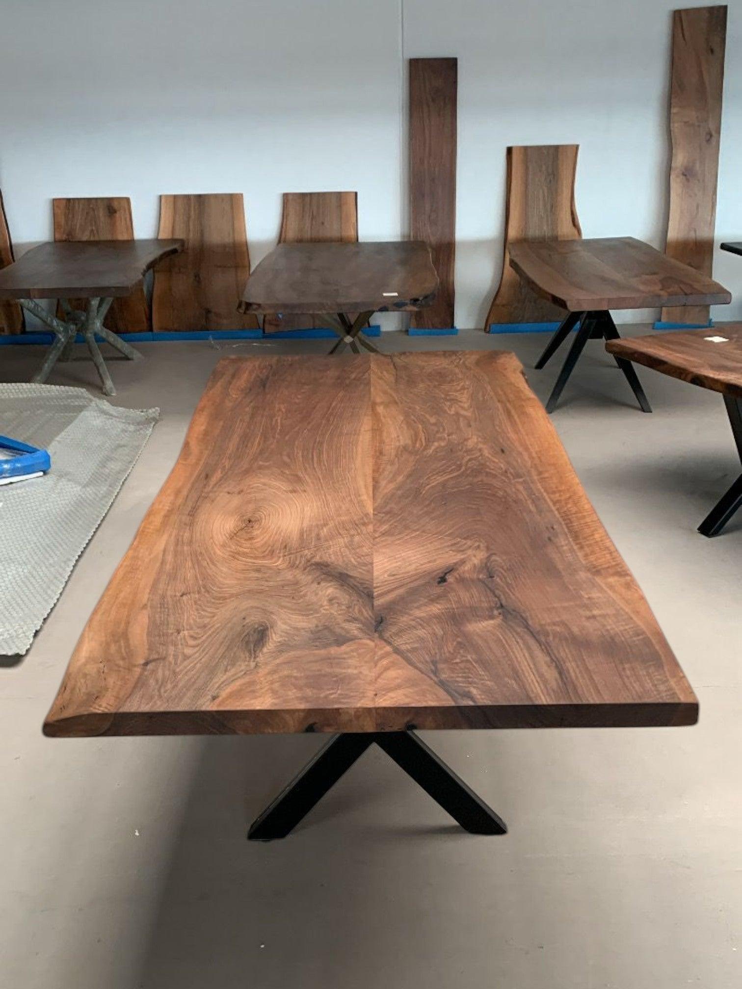 Showroom med plankeborde i valnød og mørkt træ med sort metalstel.