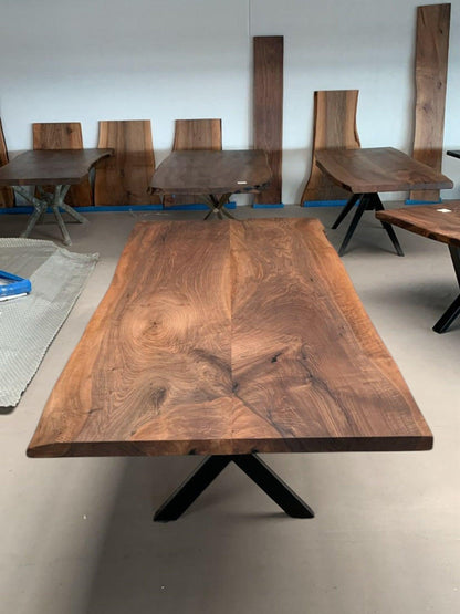 Showroom med plankeborde i valnød og mørkt træ med sort metalstel.