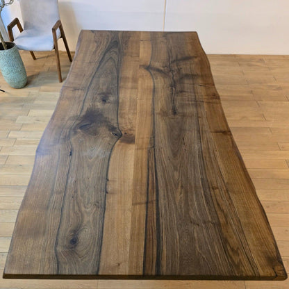 Plankebord i valnød med naturlige åretegninger og mørk overflade.