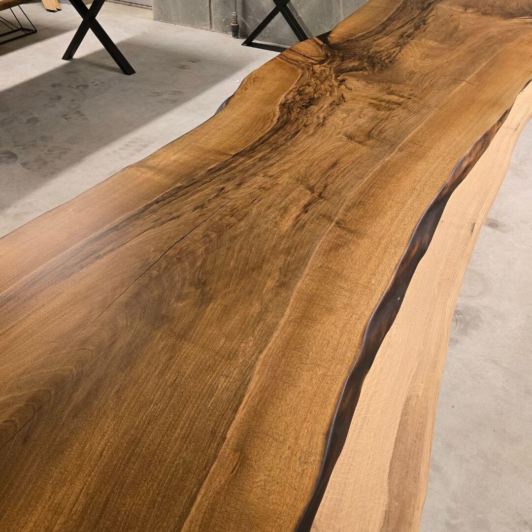 Langt valnøds plankebord med unikke åretegninger og naturkant i moderne hjem