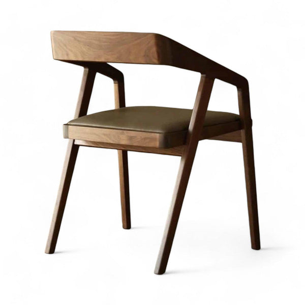 Stilren spisebordsstol i massivt valnød med skråt stel og sort sæde