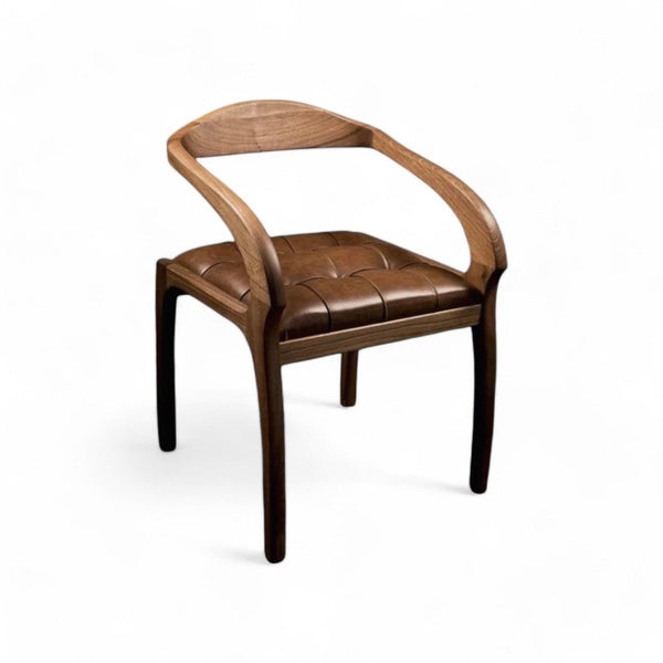 Nærbillede af spisebordsstol i valnød med brunt lædersæde og træarmlæn.