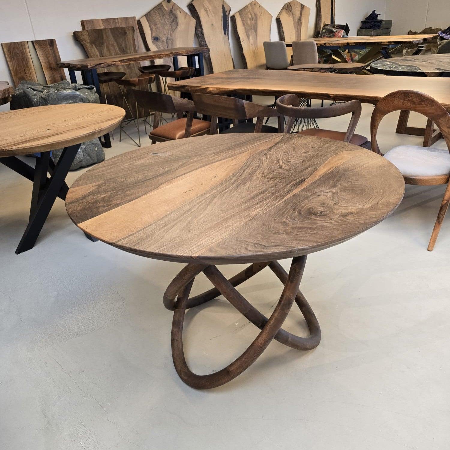 Rundt plankebord i valnød med unikt snoet træstel på showroom.