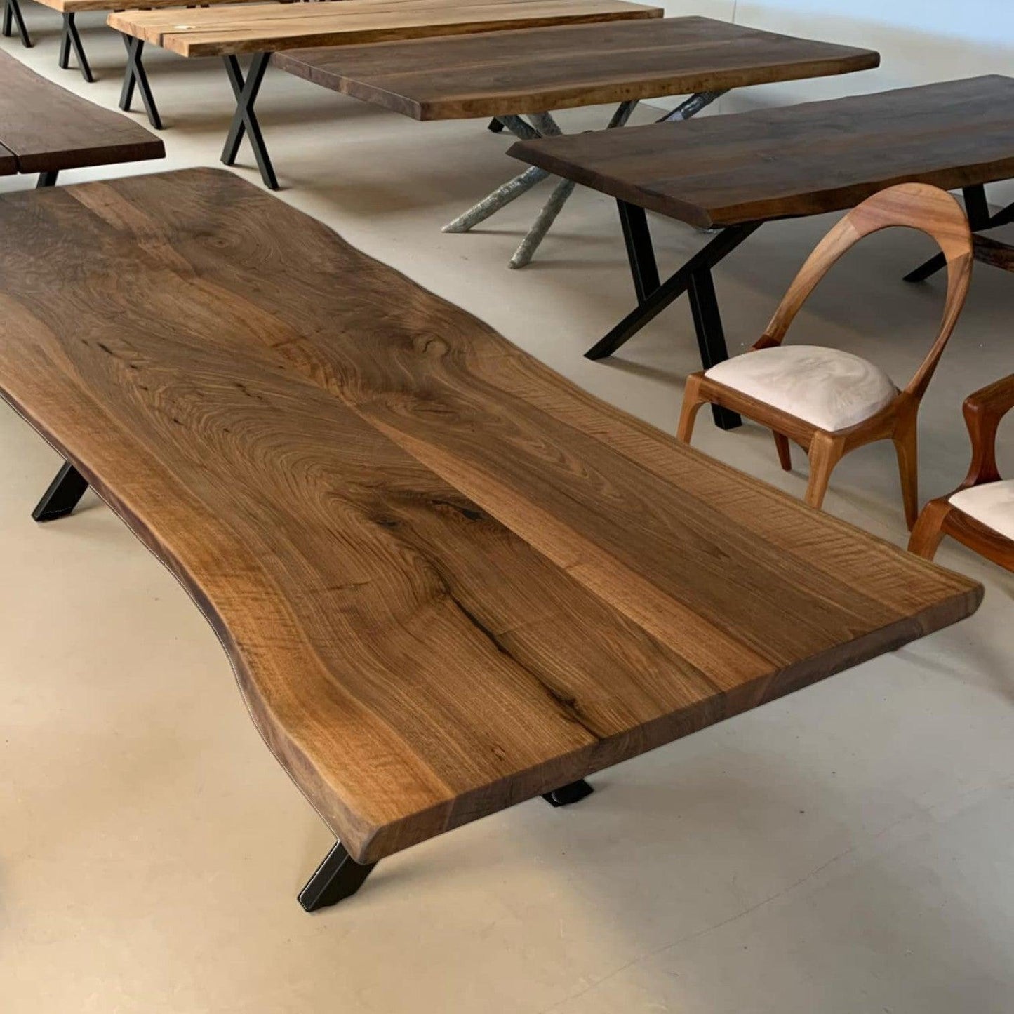 Valnød plankebord med levende kanter og sorte metalben udstillet i showroom
